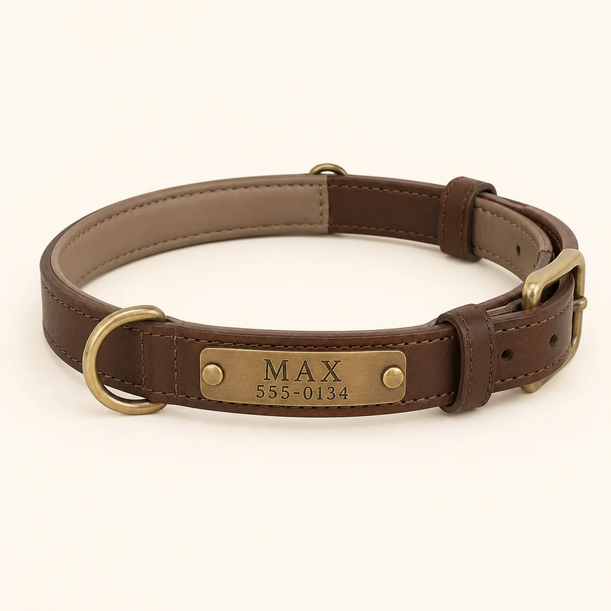 Brown leather dog collar laid open, the brass plate engraved MAX above 555-0134, brass buckle and D-ring
